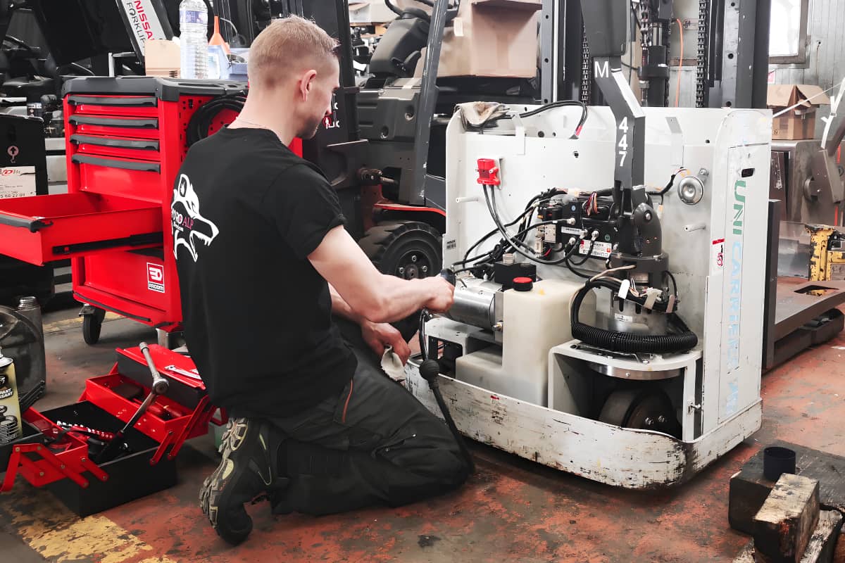 un technicien atelier vdm technologies nettoie le moteur de son gerbeur durant un entretien