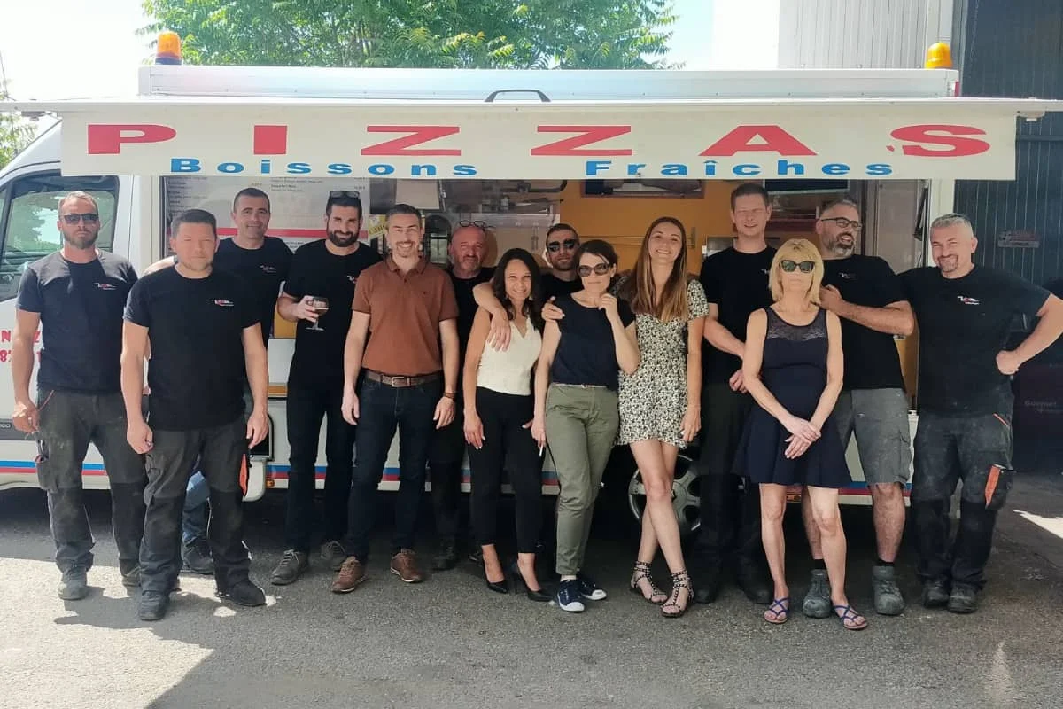 photo collaborateurs vdm technologies devant un camion pizza