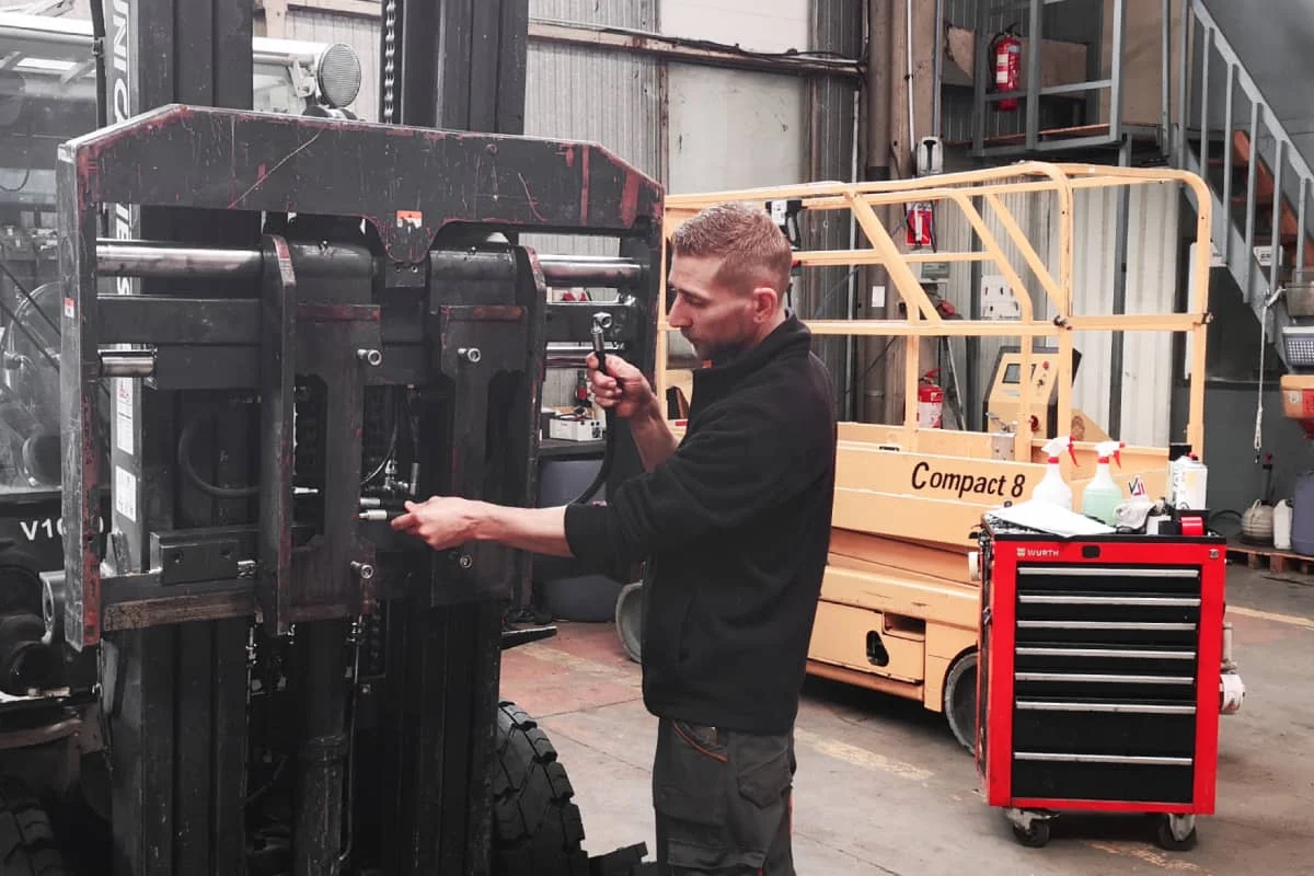 un technicien atelier vdm technologies realise l'installation de flexibles et raccords hydrauliques sur un chariot elevateur frontal