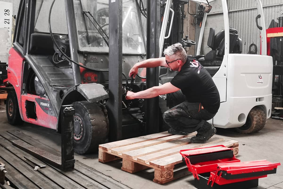un technicien atelier vdm technologies effectue l'installation de flexibles et raccords hydrauliques sur un chariot elevateur fenwick
