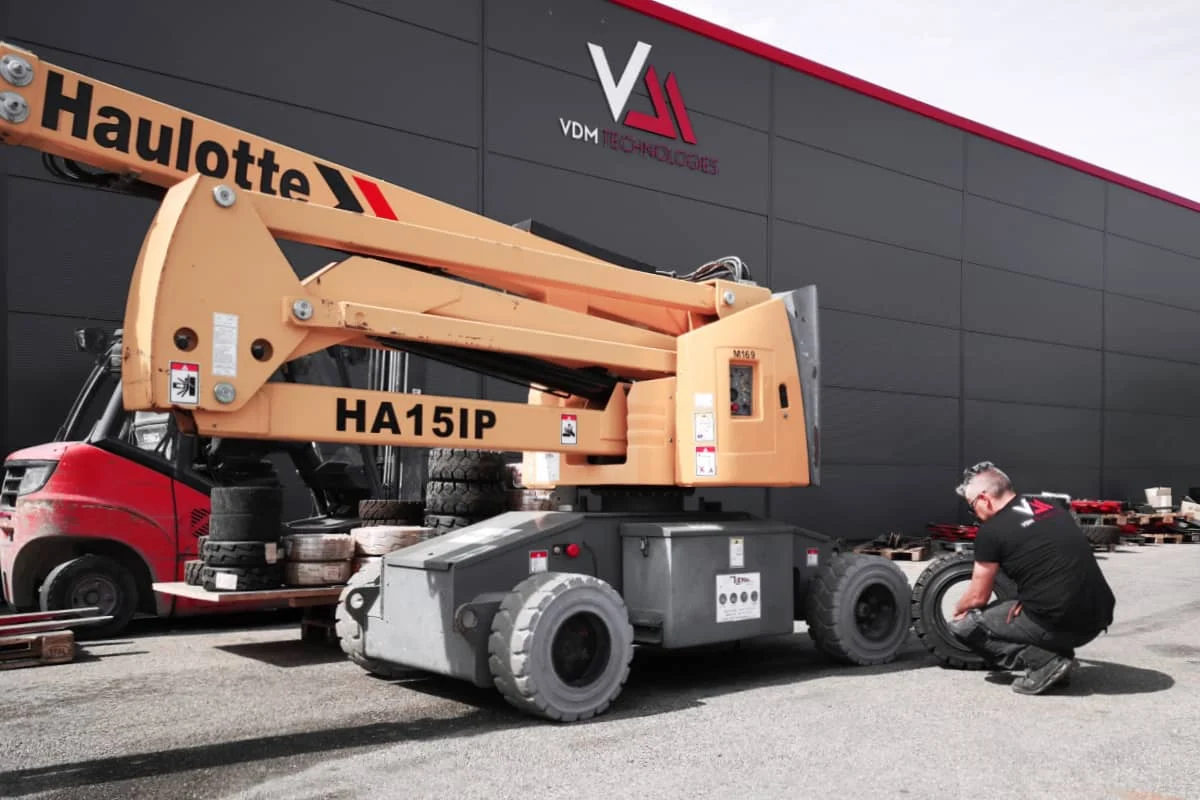 un technicien sav vdm technologies effectue le montage d'un pneu sur une nacelle haulotte
