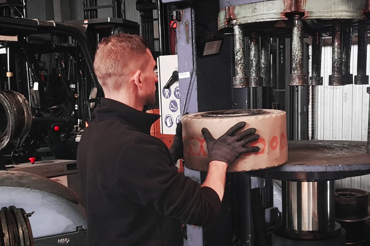 Pneus et accessoires - un technicien vdm technologies met un pneu dans la presse